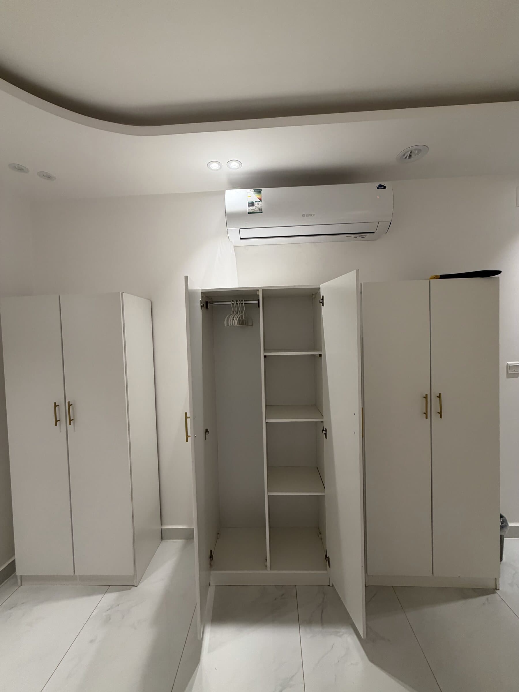 Les armoires de la chambre, cintres et étagères, sous la climatisation