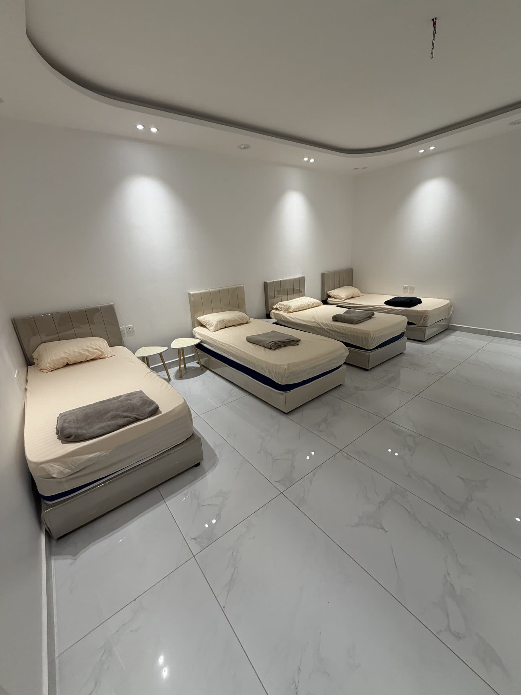 Une chambre de la villa, ses quatre lits simples et leurs serviettes pliées